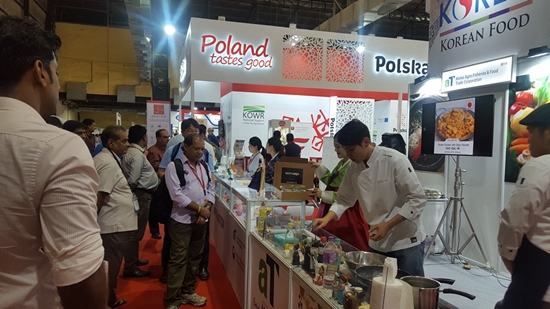 뭄바이 식품박람회 한국관을 찾은 바이어들이 참가업체 제품을 활용한 조리 시연을 살펴보고 있다.