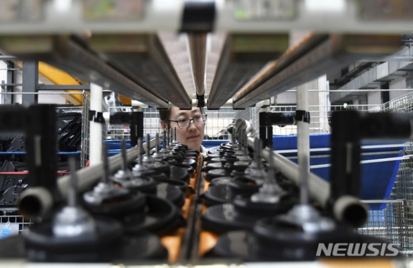 중국 산둥성 옌타이시의 자동차 에어컨 제조 공장에서 한 노동자가 부품을 검사하고 있다.Ⓒ뉴시스
