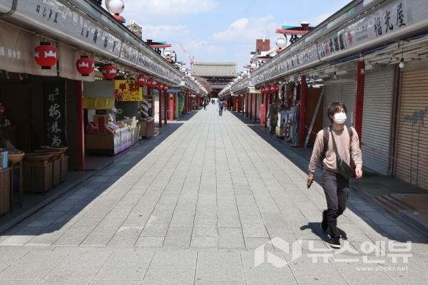 지난 8일 일본 도쿄 아사쿠사의 상점가 '나카미세' 거리가 텅 빈 가운데 한 시민이 마스크를 쓴 채 걸어가고 있다. 지난 7일 도쿄 등 7개 지역에 신종 코로나비아러스 감염증(코로나19) 확산을 막기 위해 긴급사태 선언이 발령됐다. ⓒAP/뉴시스