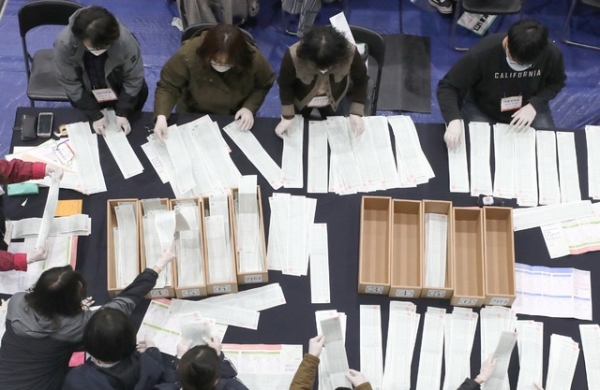 제21대 국회의원 선거가 종료된 16일 자정 서울 종로구 경복고등학교 강당에 마련된 종로구 개표소에서 개표사무원들이 비례대표 투표용지를 수기 분류하고 있다. / 사진 = 뉴시스