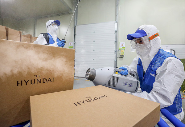 경기도 김포시에 위치한 물류센터에서 전문 방역업체 직원들이 초미립자 분사기를 활용해 선물세트를 소독하고 있다.  /사진=현대백화점 제공