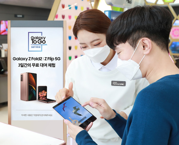 서울 강남구 삼성 디지털프라자 도곡점에서 고객이 갤럭시 팬큐레이터의 안내를 받으며 '갤럭시 Z 폴드2' 로 '개체 지우기(AI 지우개)' 기능을 체험해보고 있다.