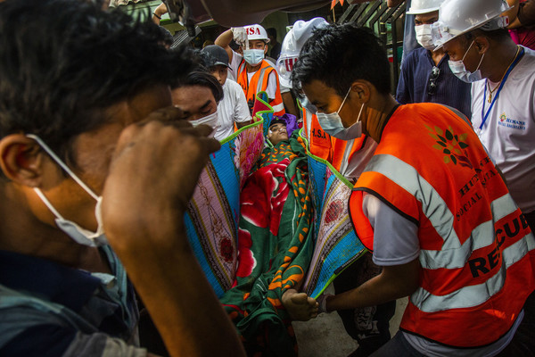 11일 미얀마 양곤에서 반 군부 시위대가 미얀마 군경의 총탄에 머리를 맞고 숨진 친 민 뚜(25)의 시신을 옮기고 있다. 친 민 뚜는 11일 세 살배기 아이와 임신 중인 아내를 뒤로하고 반 군부 시위에 참석했다가 주검으로 돌아왔다.  사진/뉴시스.