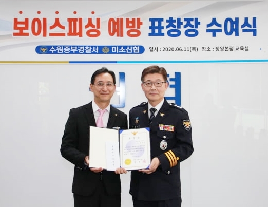 미소신협 송인욱 차장(왼쪽)이 정희영 수원중부경찰서장(오른쪽)으로부터 보이스 피싱 인출책 검거 공로를 치하하는 표창장을 받는 모습.  사진/신협