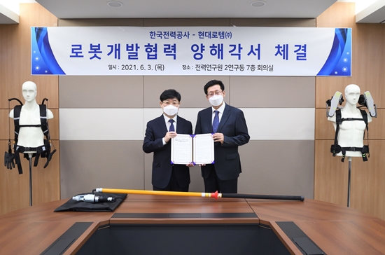 지난 3일 대전에 위치한 한전 전력연구원에서 송기욱 한전 전력연구원 융복합프로젝트연구소장(왼쪽)과 안경수 현대로템 디펜스솔루션사업본부장(오른쪽)이 기념촬영을 하고 있다. 사진/현대로템