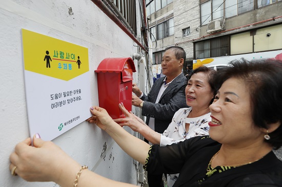 서울 서대문구 북아현동 일대에서 ‘서대문구 북아현동 이웃살피미’ 관계자들이 주민들이 어려운 이웃을 동주민센터에 알리거나 스스로 도움을 요청할 수 있는 ‘사람사이 우체통’을 설치하고 있다. 이들은 취약지역에 ‘주변 어려운 이웃을 알려달라’는 내용의 안내 포스터를 부착하고 어느 이웃에게 어떤 도움이 필요한지 써넣을 수 있는 엽서를 비치해 고독사를 예방할 계획이다. 사진/ 뉴시스 제공