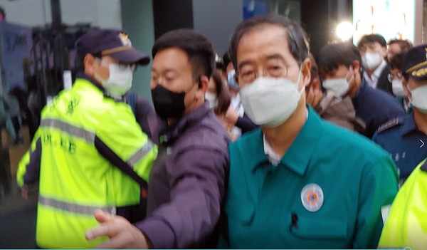 한덕수 총리가 지난 31일 오후 5시경 이태원 참사 현장에서 자신에게 질문하는 기자에게 위력을 가하는 경호 인력의 모습을 쳐다보며 빠져나가고 있다.  
