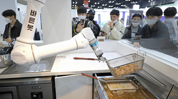 로봇월드 2022에서 선보인 치킨 조리 로봇의 모습. 최근 서비스업종에서 로봇의 위상이 커지고 있다. 사진/뉴시스