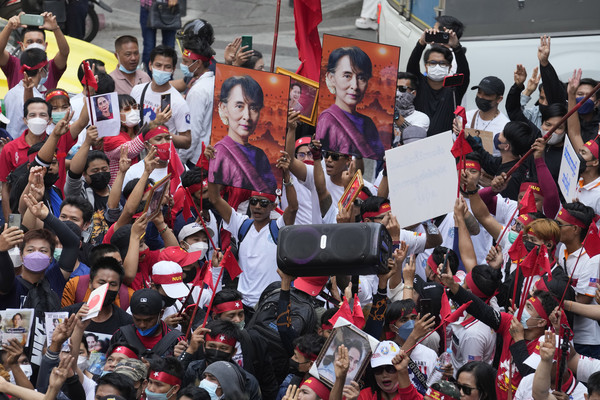 태국 거주 미얀마인들이 1일(현지시간) 방콕의 미얀마 대사관 밖에서 미얀마 군부 쿠데타 2년을 맞아 민주화 시위를 하면서 아웅 산 수치 전 미얀마 국가 고문의 사진을 들고 저항의 상징인 세 손가락 경례를 하고 있다.  (사진/뉴시스)