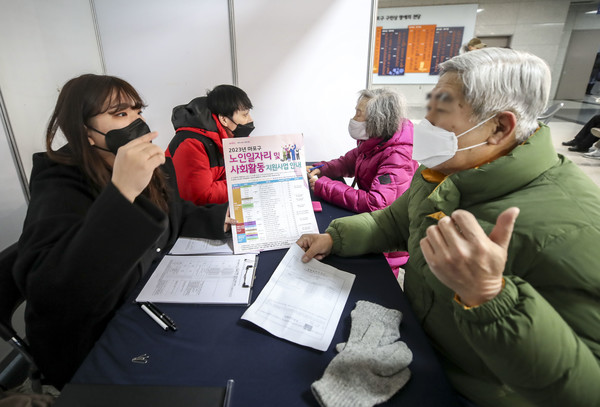 작년 12월 서울 마포구청에서 열린 2023년 노인일자리 사회활동 지원사업 박람회를 찾은 노인들이 신청서 작성을 하기 위해 상담하고 있다. 사지/뉴시스