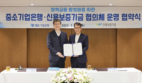 사진은 지난 30일 서울 을지로 기업은행 본점에서 열린 ‘정책금융 활성화를 위한 중소기업은행․신용보증기금 협의체 운영 협약식‘에서 김성태 IBK기업은행장(오른쪽)과 최원목 신용보증기금 이사장(왼쪽)이 협약식을 마치고 기념 촬영을 하고 있는 모습. / 사진 = IBK기업은행 제공