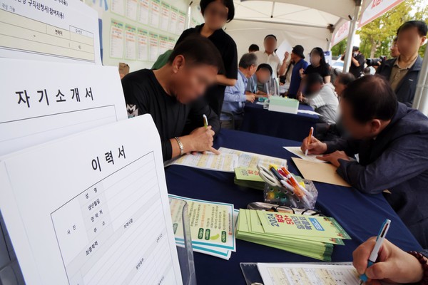 '2024년 부산 50+일자리 박람회'가 열린 지난 17일 부산 부산진구 부산시민공원에서 중·장년 구직자들이 구직신청서 등을 작성하고 있다.    사진/뉴시스