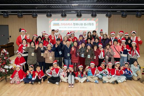 우리(WOORI) 가족 봉사단이 크리스마스 나눔 행사에 참여한 서울 마포구 염리종합사회복지관 어르신과 함께 기념촬영을 하고 있다. / 사진 = 우리은행 제공