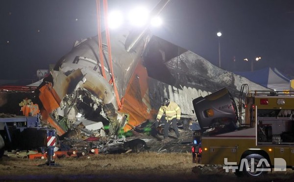 지난 29일 전남 무안국제공항에서 발생한 태국발 제주항공 여객기 충돌 폭발 사고 현장에서 소방대원들이 수색견을 동원해 야간 수색 작업을 진행하고 있다.   사진/뉴시스