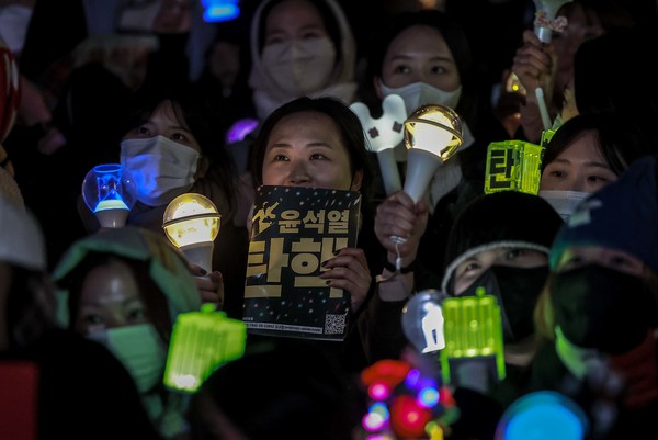 윤석열 대통령 탄핵소추안 재표결이 가결된 작년 12월 14일 서울 영등포구 국회 앞에서 열린 '내란수괴 윤석열 즉각탄핵' 범국민 촛불대행진에서 시민들이 기뻐하고 있다.     사진/뉴시스