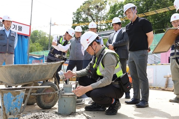 롯데건설 직원이 서초 헌인마을 현장에서 '차세대 혼화제'가 적용된 콘크리트를 테스트하고 있다. / 사진 = 롯데건설 제공