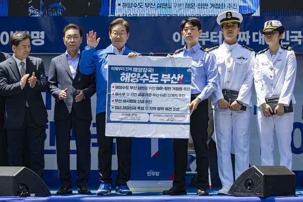 이재명 더불어민주당 대선 후보가 지난14일부산 부산진구 서면 젊음의 거리에서 열린 유세에서 권기흥 에이치라인해운해상직원노조 위원장과 해양수도 부산 협약서에 서명한 뒤 기념촬영을 하고 있다.       사진/뉴시스