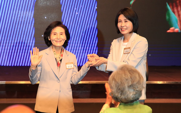 이재명 더불어민주당 대선 후보의 부인 김혜경 여사와 김문수 국민의힘 대선후보의 부인 설난영(왼쪽) 여사가 지난 12일 서울 중구 신라호텔에서 열린 중앙신도회 창립 70주년 기념식에서 손을 맞잡고 있다.    사진/뉴시스