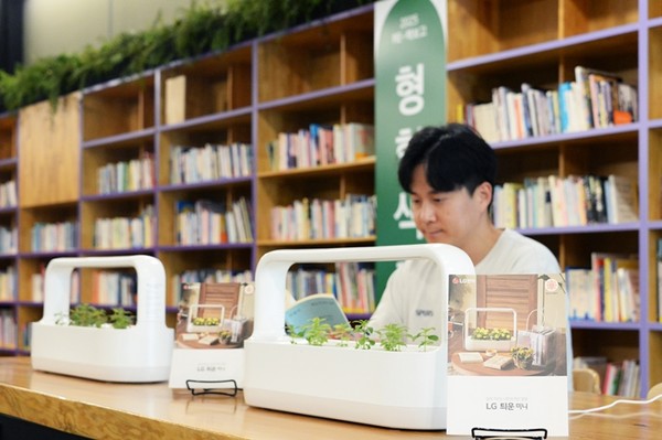 LG전자가 'LG 틔운 미니'를 활용해 조성된 내부 서가와 열람실 공간에서 독서하며 다양한 식물을 감상하는 모습. / 사진 = LG전자 제공