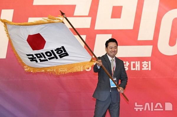 장동혁 신임 국민의힘 대표가 26일 서울 여의도 국회도서관에서 열린 국민의힘 제6차 전당대회 결선에서 선출된 뒤 당기를 흔들고 있다.    사진/뉴시스