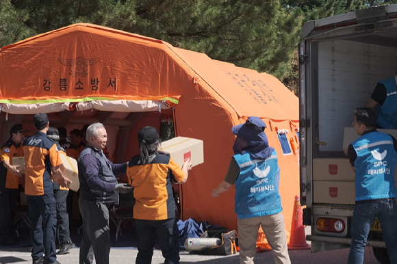 SPC그룹 해피봉사단이 10일 강릉시 강북공설운동장에서 가뭄 대응 현장 소방관과 지원 인력들에게 전달할 빵을 옮기고 있다. / 사진 = SPC그룹 제공