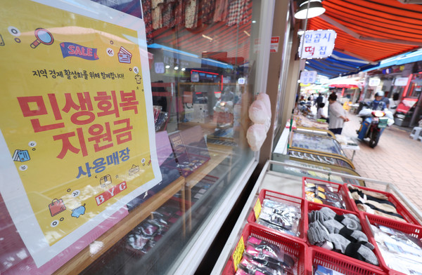 소득 상위 10%를 제외한 국민 90%에게 1인당 10만원을 추가 지급하는 2차 '민생회복 소비쿠폰' 신청과 지급이 시작된 지난 22일 서울의 한 전통시장에 민생 회복 지원금 사용가능 안내문이 붙어 있다.   사진/뉴시스